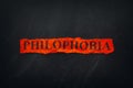 Word Philophobia on red torn piece of paper