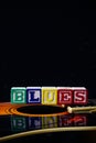 Word or phrase Blues made with letter cubes, standing on guitar. Royalty Free Stock Photo