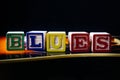 Word or phrase Blues made with letter cubes, standing on guitar. Royalty Free Stock Photo