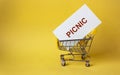 The word Picnic in a basket on a yellow background