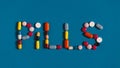 Word Pills Is Lined With Colored Pills And Tablets On A Blue Background, Top View Royalty Free Stock Photo