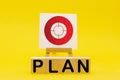 The word PLAN and sign stand on a yellow background. Hit exactly on center. Tactics of advertising targeting. advertise campaigns Royalty Free Stock Photo