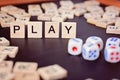 Word PLAY with wooden letters on black Board with dice and letter in the circle Royalty Free Stock Photo