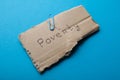 The word `poverty` on a piece of cardboard on a blue background. Royalty Free Stock Photo
