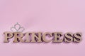 Word Princess abstract wooden letters. Pink background with sparkling crown. Royalty Free Stock Photo