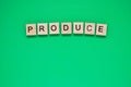 Word produce. Top view of wooden blocks with letters on green surface