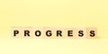 Word progress made with small wooden blocks on yellow Royalty Free Stock Photo