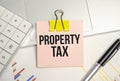 the word Property Tax is written in a notebook and calculator Royalty Free Stock Photo