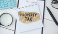 Word Property Tax is written in a notebook lying on a black table with a pen, glasses and a calculator Royalty Free Stock Photo