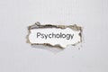 The word psychology appearing behind torn paper.