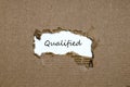 The word qualified appearing behind torn paper