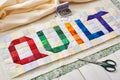 The word quilt sewn from colorful square and triangle pieces of fabric
