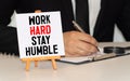 Word quotes of WORK HARD STAY HUMBLE on colorful memo papers with wooden background