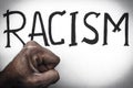 Word Racism and male fist African. Concept of racial discrimination. Stop racism and nationalism. Equality of races