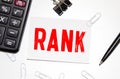 the word RANK is written on a notebook and a white background