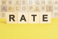 word rate is written on wooden cubes on a bright yellow surface, concept