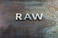 The word raw laid with silver metal letters on hot rolled steel sheet surface Royalty Free Stock Photo
