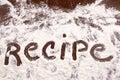 Word recipe written in white flour on wooden table