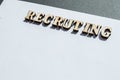 The word recruiting is written in wooden letters on a white background, the concept of hiring employees, recruitment in business