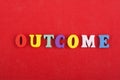 OUTCOME word on red background composed from colorful abc alphabet block wooden letters, copy space for ad text. Learning english