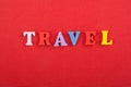 TRAVEL word on red background composed from colorful abc alphabet block wooden letters, copy space for ad text. Learning english Royalty Free Stock Photo