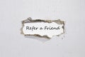 The word refer a friend appearing behind torn paper. Royalty Free Stock Photo