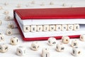 Word Refinance written in wooden blocks in red notebook on white wooden table