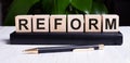 The word REFORM is written on the wooden cubes of the diary near the handle Royalty Free Stock Photo