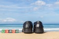 word RELAX in colorful alphabet blocks and black shoe on tropical beach Royalty Free Stock Photo