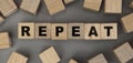 The word REPEAT made from wooden cubes. Conceptual photo