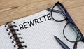 The word REWRITE is written in a notebook with glasses Royalty Free Stock Photo
