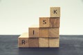 The word `risk` on wooden blocks. The concept of the economic crisis, development strategy, the fall of the economy.Ladder made of Royalty Free Stock Photo
