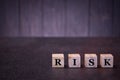 The word risk on wooden cubes, on a dark background, light wooden cubes signs, symbols signs