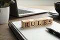 Word Rules made of cubes with letters on wooden table