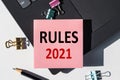 The word RULES 2021 on a notebook shown by a business woman