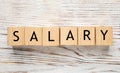 Word Salary made with cubes on white wooden table, flat lay