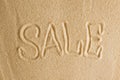 The word sale is painted in the sand. Beach background. Top view. The concept of summer, summer kanikkuly, vacation, holydays Royalty Free Stock Photo