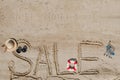 The word sale is painted on the sand. Beach background. View from above. The concept of summer, summer kanikkuly, vacation, Royalty Free Stock Photo