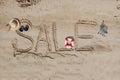 The word sale is painted on the sand. Beach background. View from above. The concept of summer, summer kanikkuly, vacation, Royalty Free Stock Photo