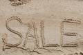 The word sale is painted on the sand. Beach background. View from above. The concept of summer, summer kanikkuly, vacation, Royalty Free Stock Photo