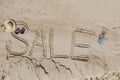 The word sale is painted on the sand. Beach background. View from above. The concept of summer, summer kanikkuly, vacation, Royalty Free Stock Photo