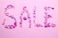 The word `sale` of pink rose petals on a pink background. Shopping, sale concept.