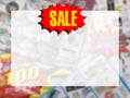 word SALE on red speech bubble with copy space over blurred catalogue background. Royalty Free Stock Photo