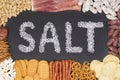 Word salt written with sea salt surrounded by food containing a lot of salt