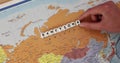 Word Sanction constructed from white cubes lies on Russia map