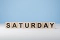 Word Saturday on wooden cubes. Weekday concept. Saturday inscription on wooden cubes on blue background. copy space
