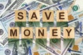 Word, Save Money composed of letters on wooden building blocks against the background of dollar bills. Concept business, finance. Royalty Free Stock Photo