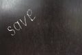 Word save written left with white chalk on a blackboard.