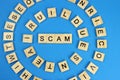 Word scam is made of wooden letters on a blue background