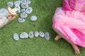 The word school spelt out in letter pebbles with a small girl sat cross legged next to it